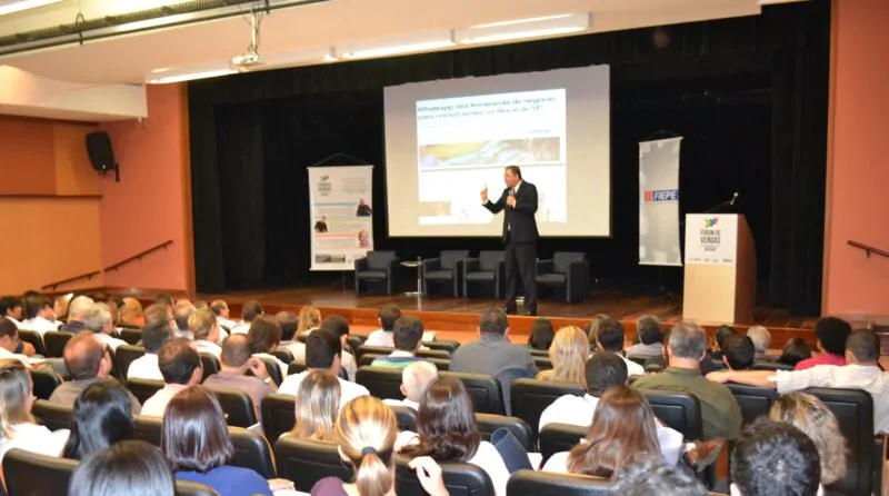 Palestrante em palco falando com público