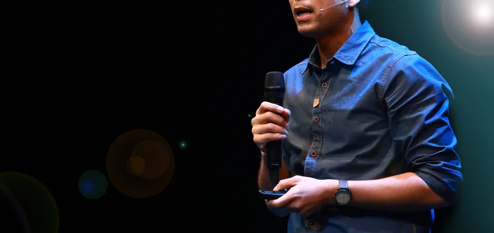 Homem falando com microfone na mão